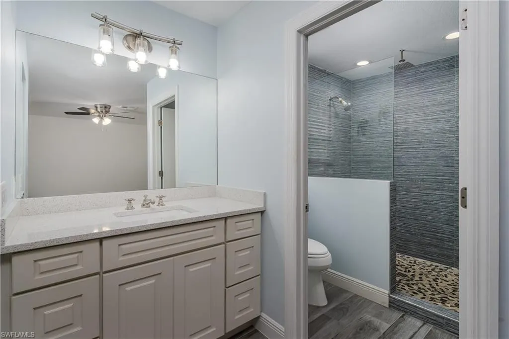 Renovated bathroom with walk-in tile shower and quartz vanity